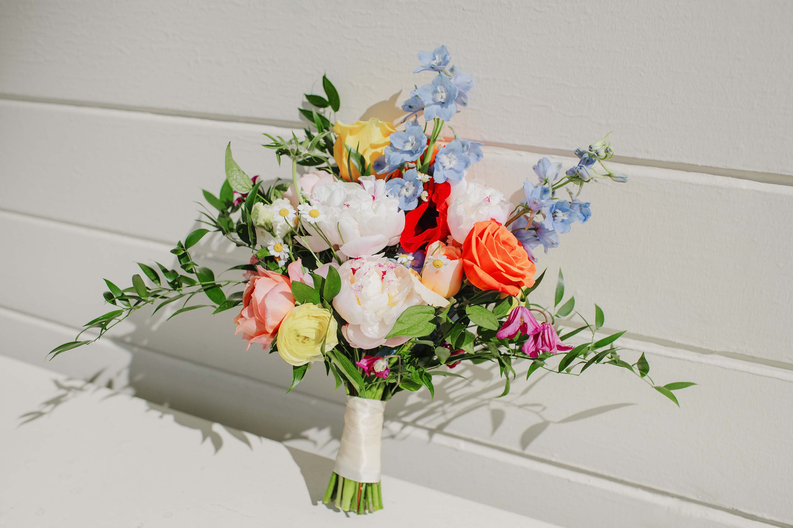 beautiful bride's bouquet with colorful roses, peonies, ranunculus and flowers of all kinds and colors photographed by Love Knot Photography