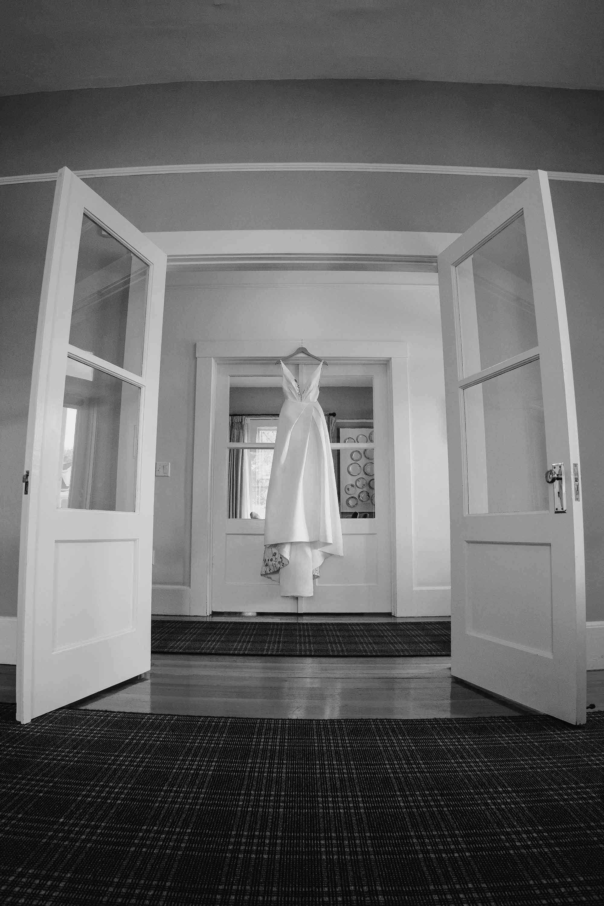 Love Knot Photography captures beautiful photograph of wedding dress hanging on the wedding day in Presidio getting ready space