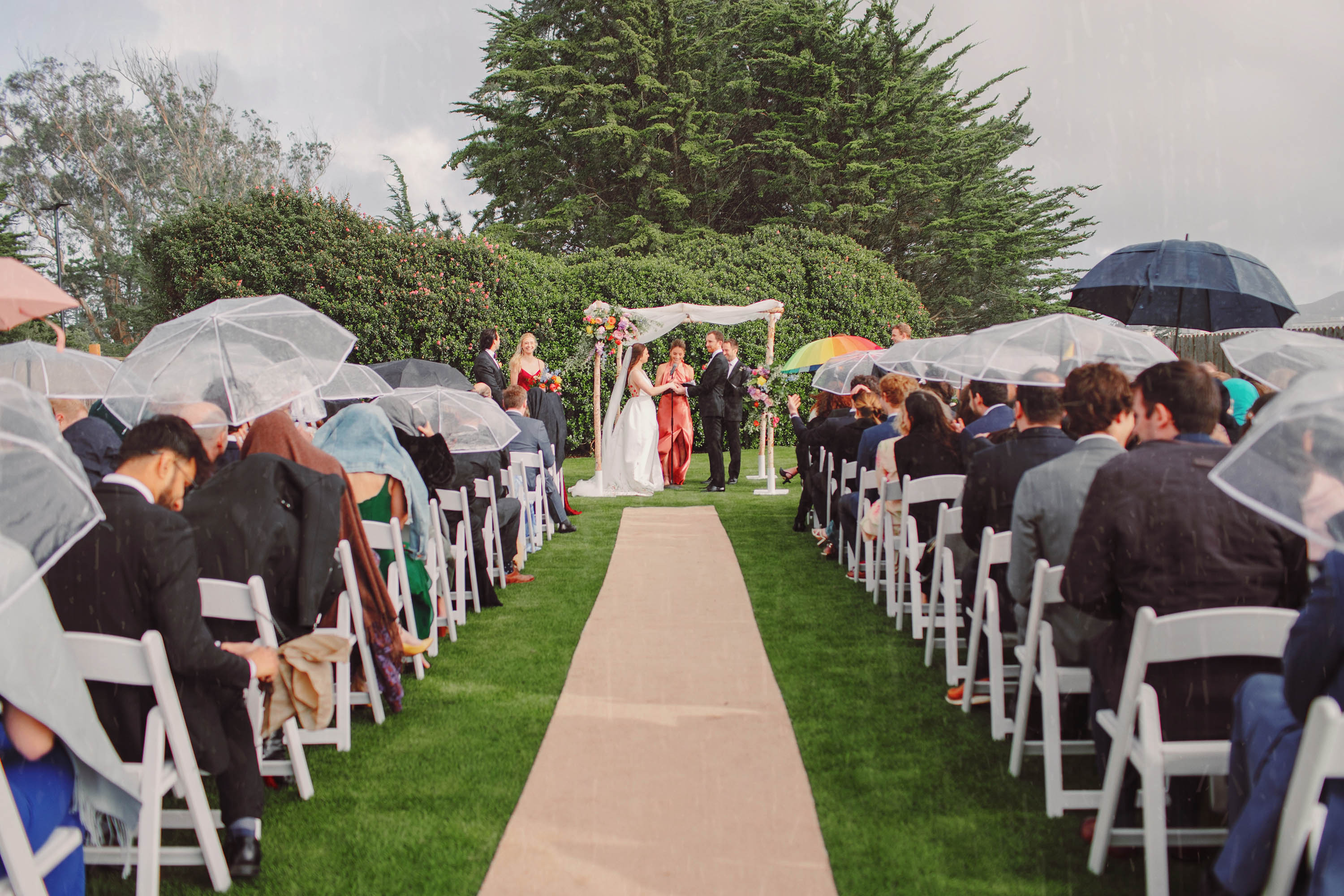 Umbrellas are out as this wedding photograph captures this magical moment during the wedding ceremony. Credit: Love Knot Photography by Isaac Klotz