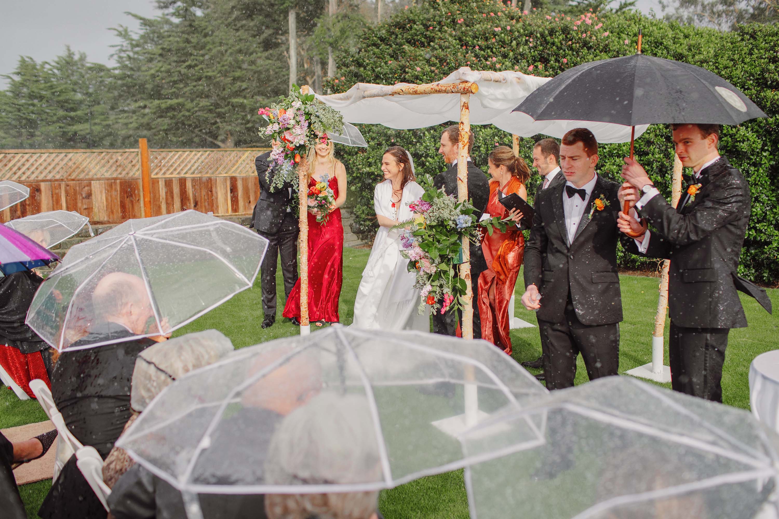 The bride smiles as the crowd cheers, rain falls, love is in the air. Credit: Love Knot Photography by Isaac Klotz