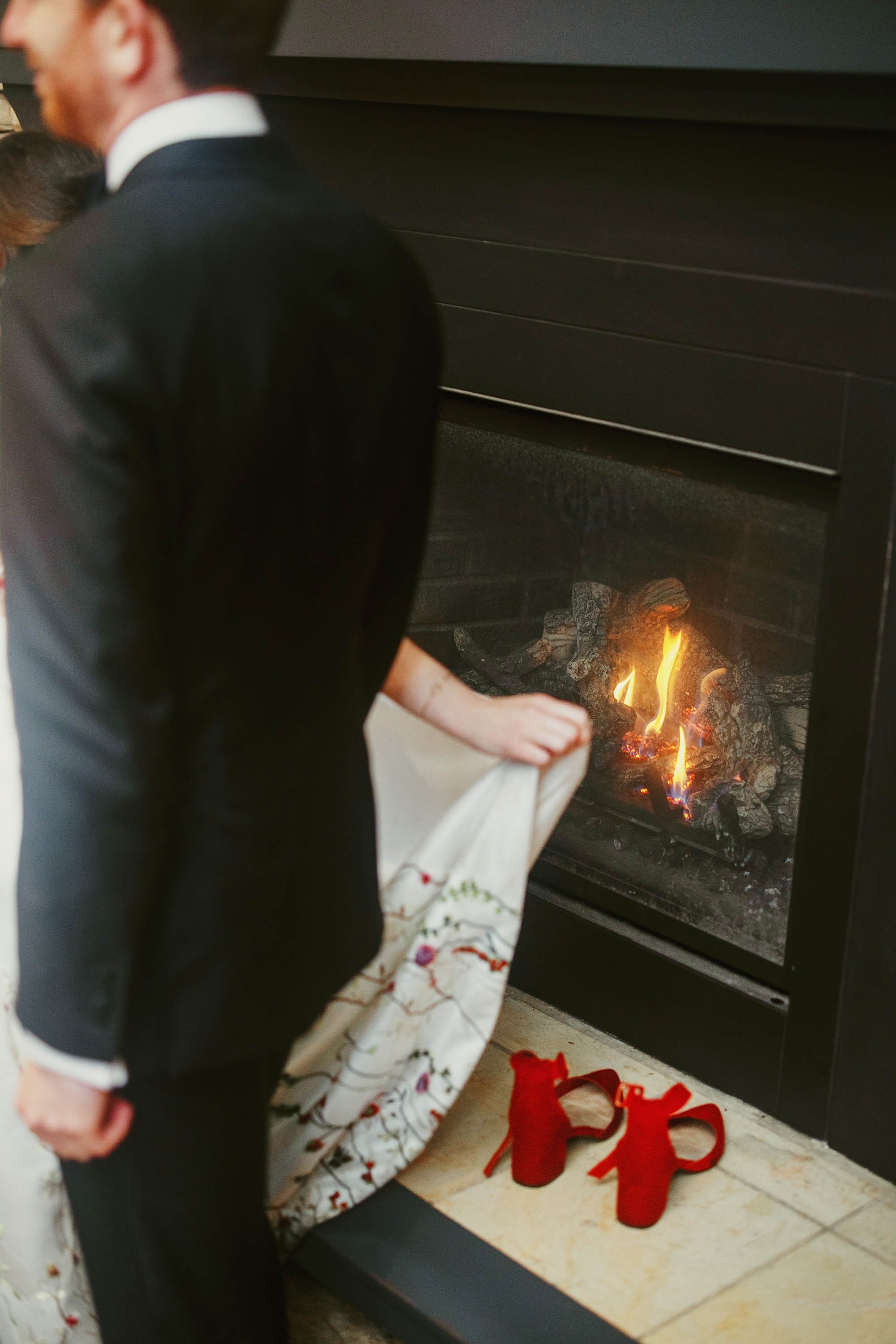Bride and groom warm up by the fire before entering their reception space. Credit: Love Knot Photography by Isaac Klotz
