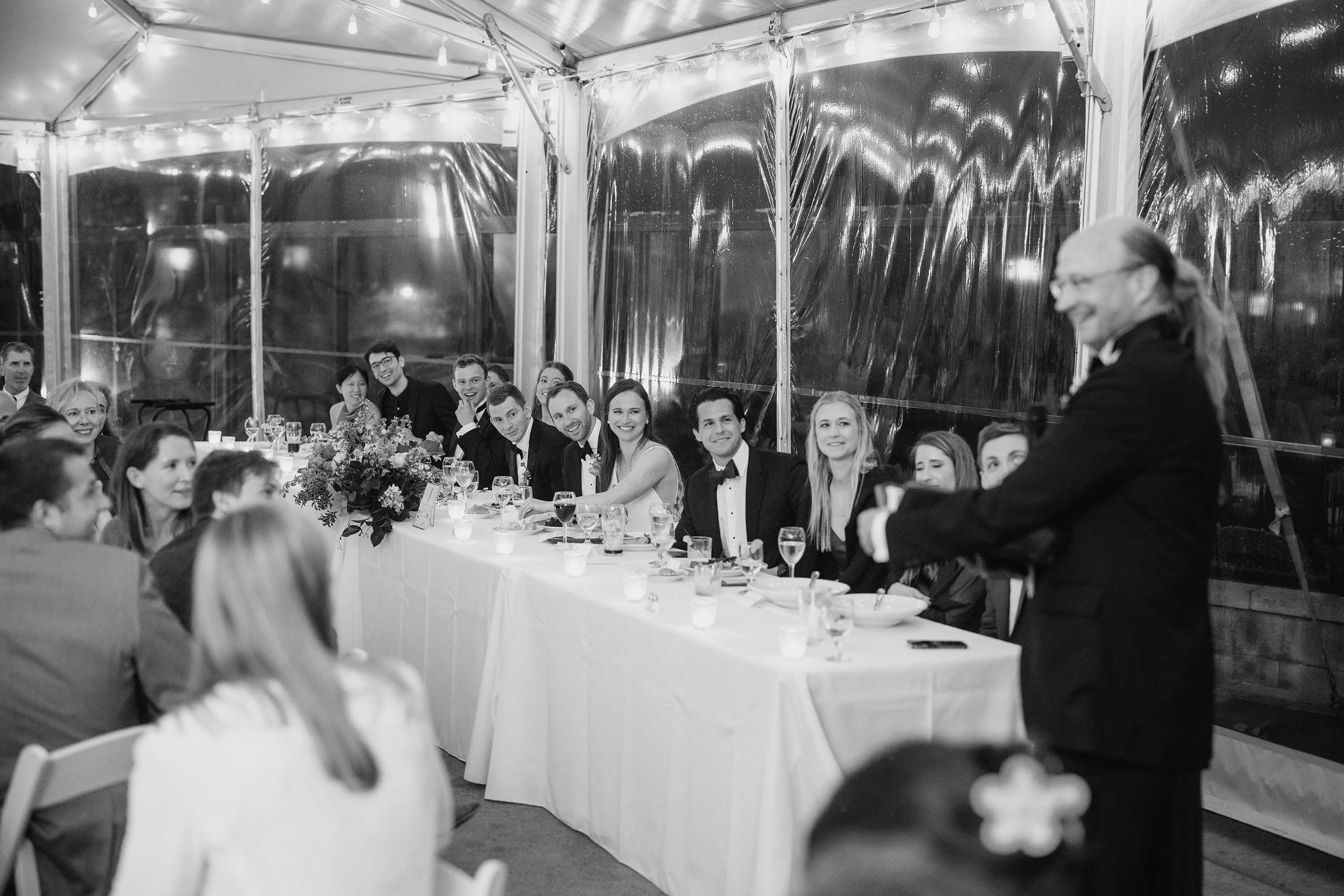 Bride and groom listen to parents giving speech at the wedding reception. Credit: Love Knot Photography by Isaac Klotz