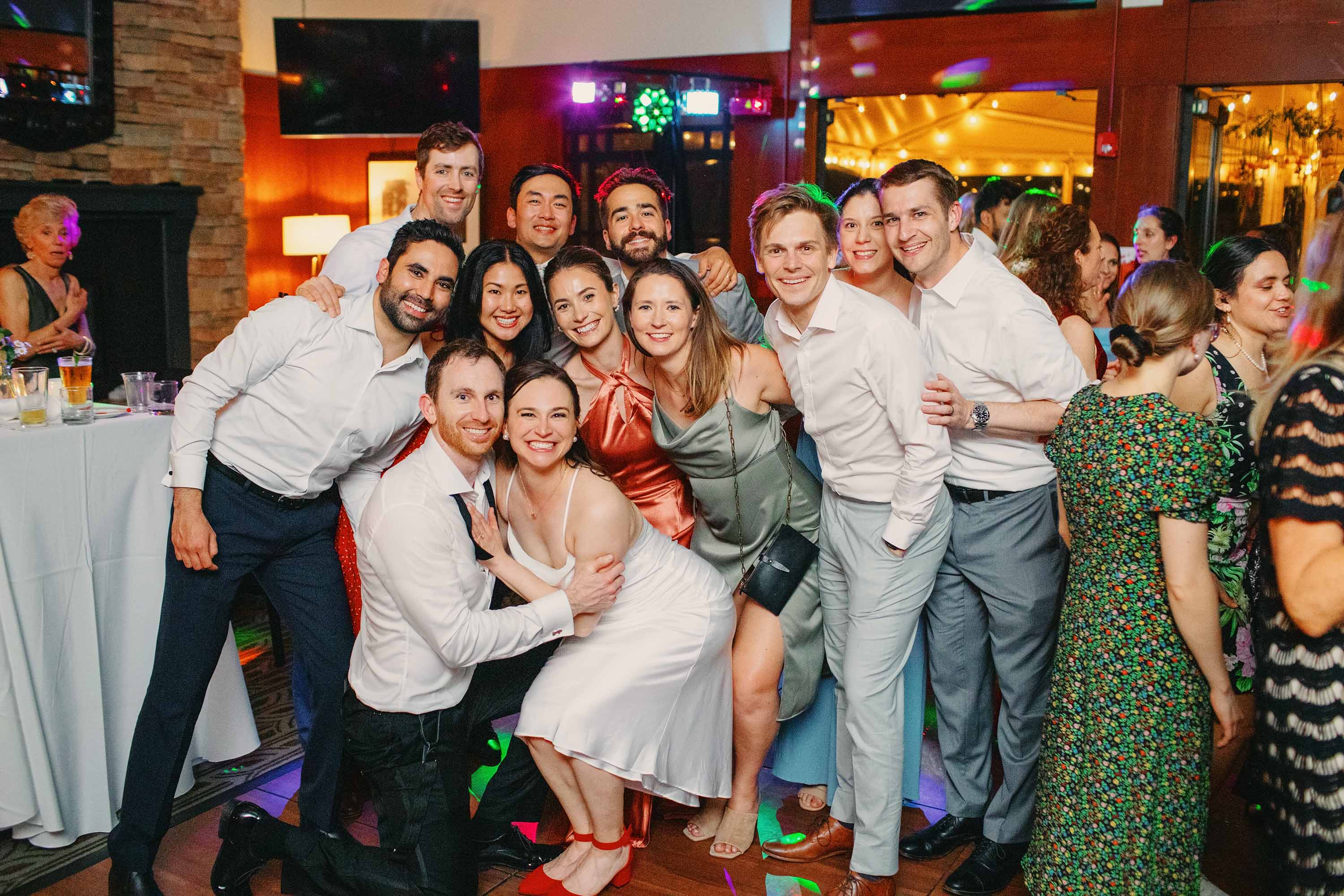 Wedding reception group photo on the dance floor, bride, groom and their friends. Credit: Love Knot Photography by Isaac Klotz