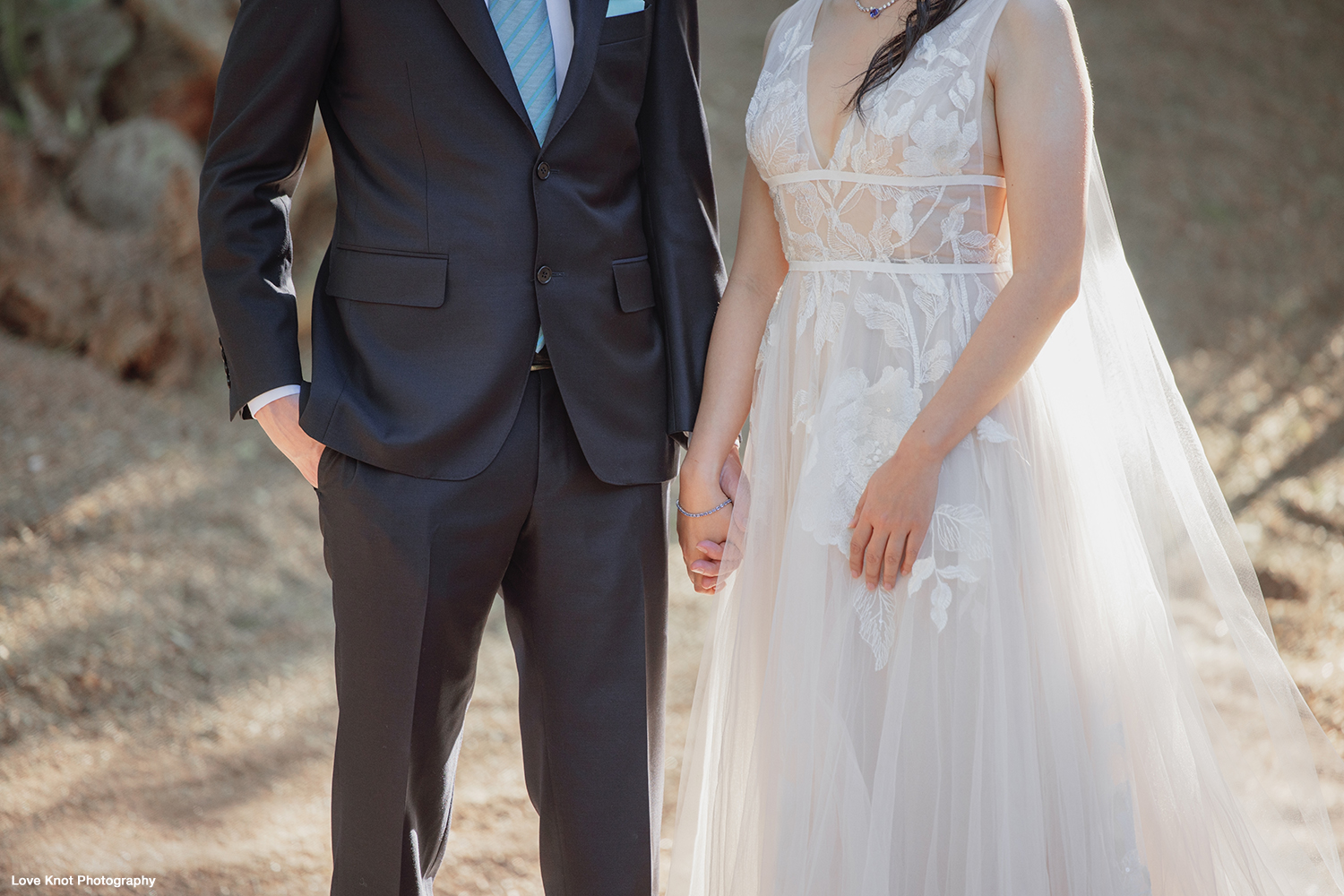 bride and groom hold hands at first look
