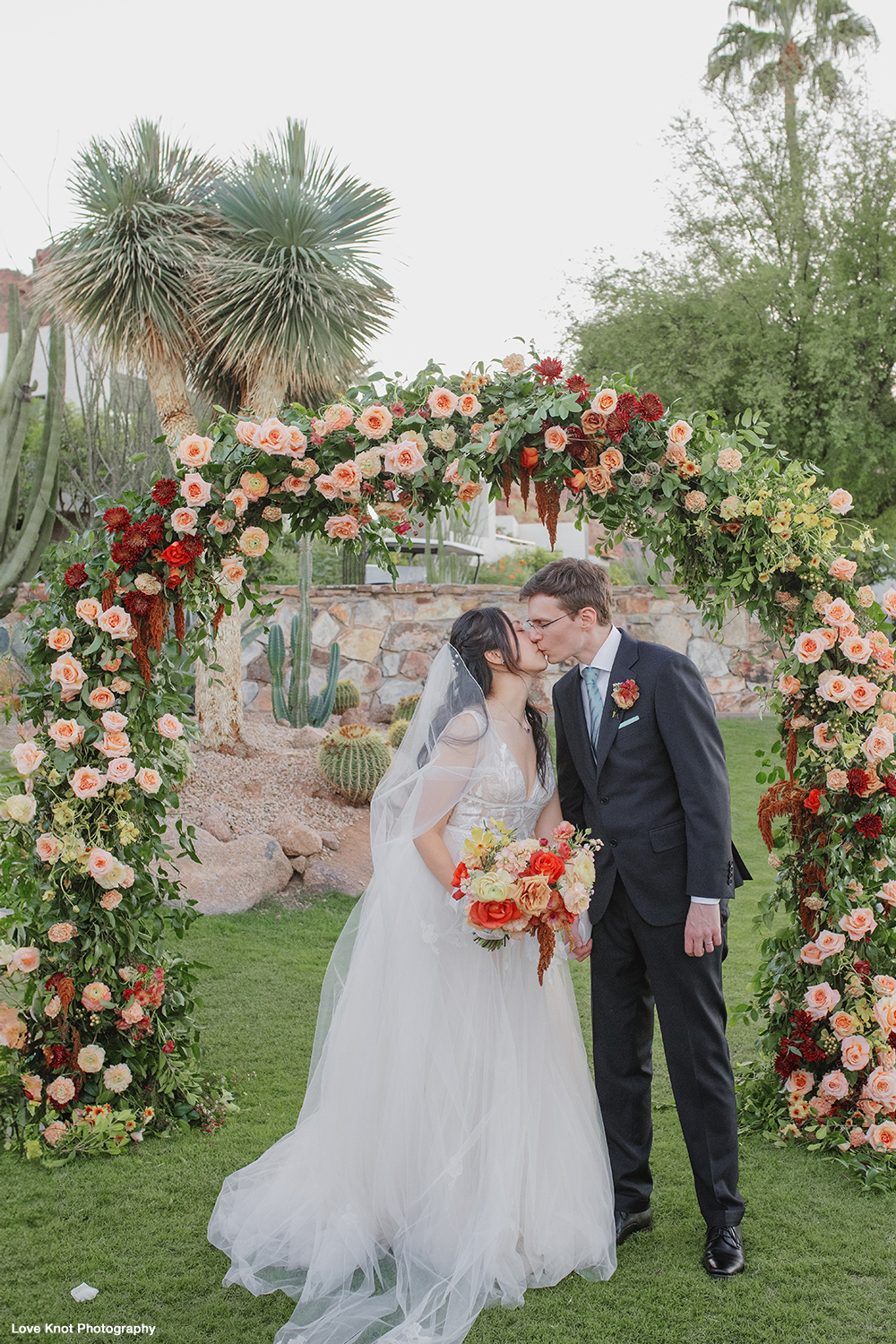 bride and groom kiss at wedding ceremony