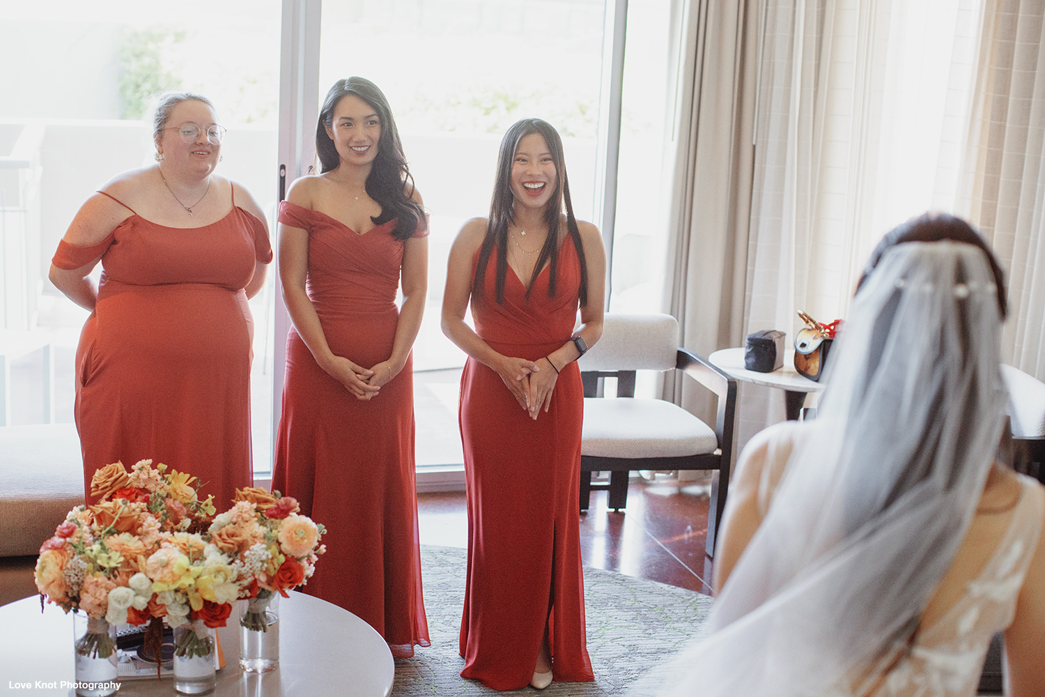 getting ready wedding photo, bride shows dress to her bridesmaids