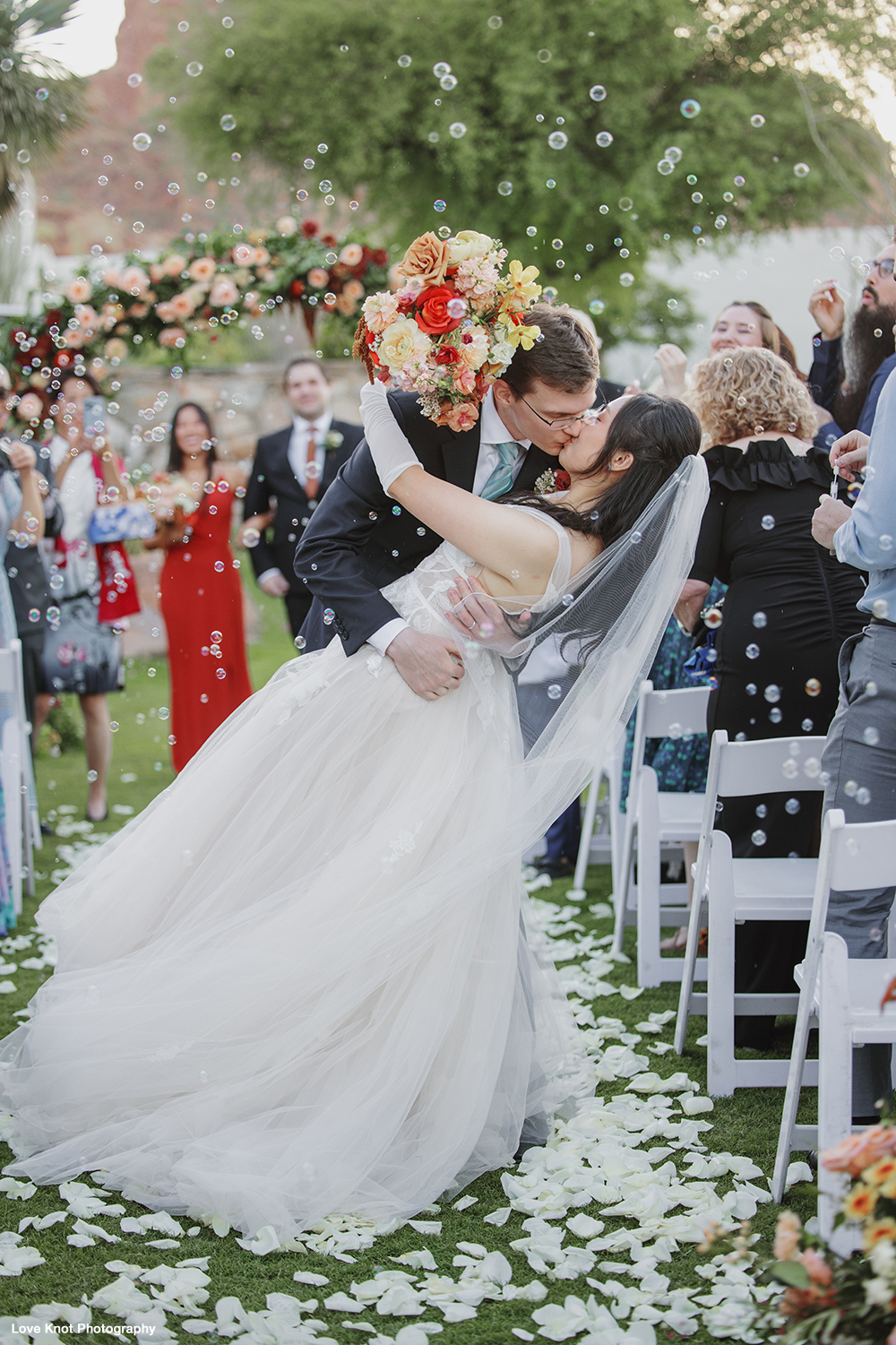 bride and groom kiss on aisle as they leave wedding ceremony