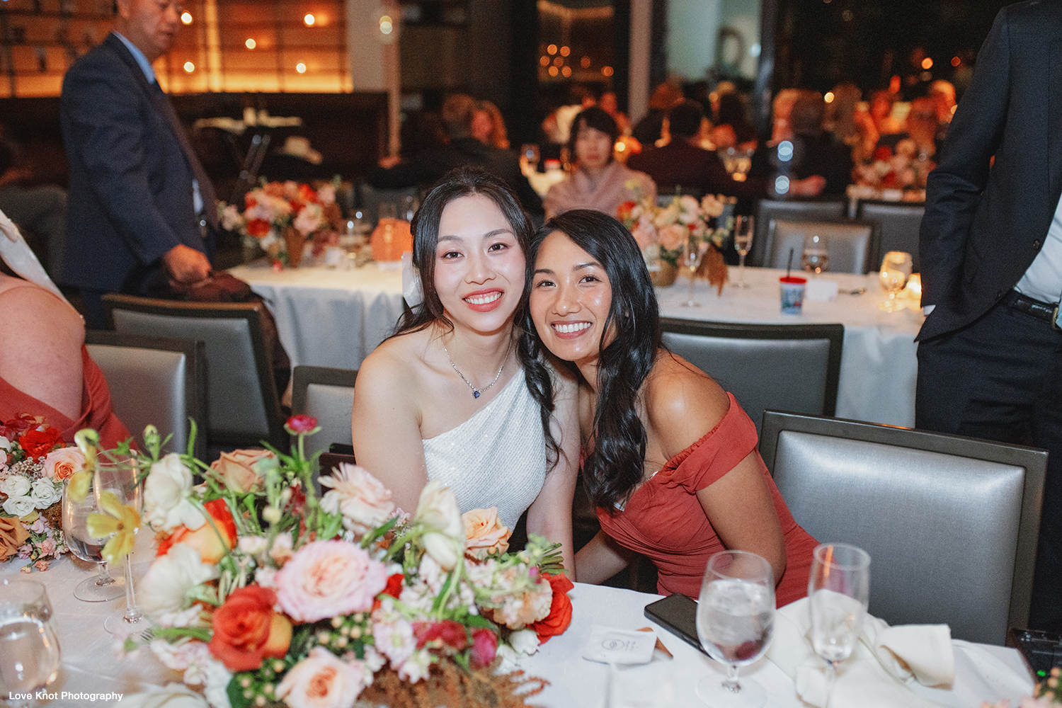 wedding day photo of bride with bridesmaid at reception