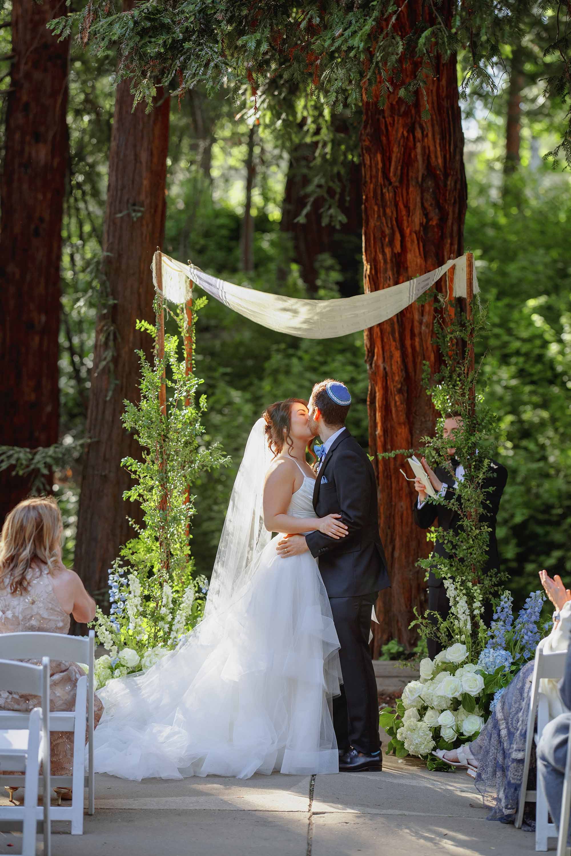 bride and groom kiss at wedding ceremony